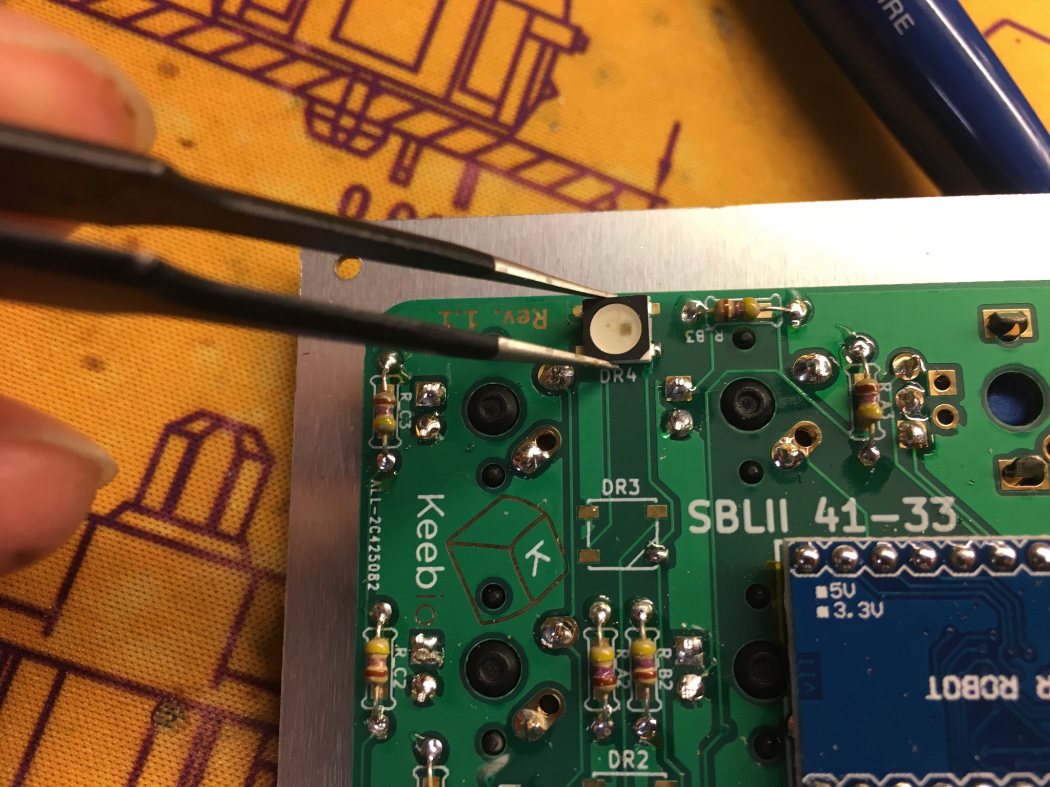 Tweezers placing RGB LED on pad