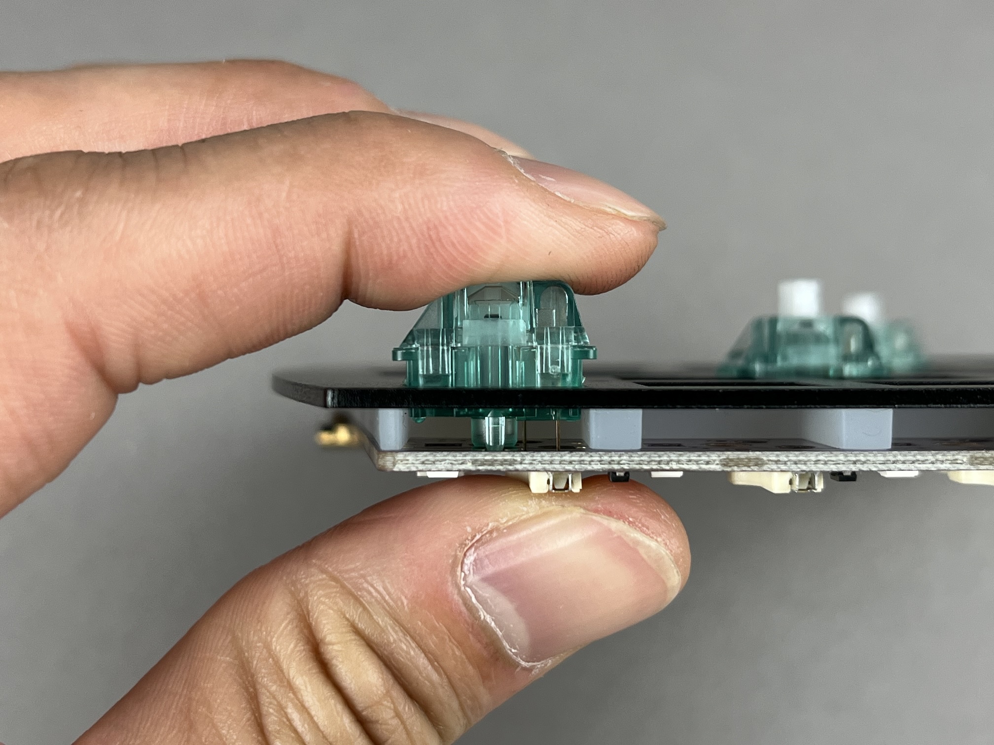 Fingers squeezing switch into hotswap socket