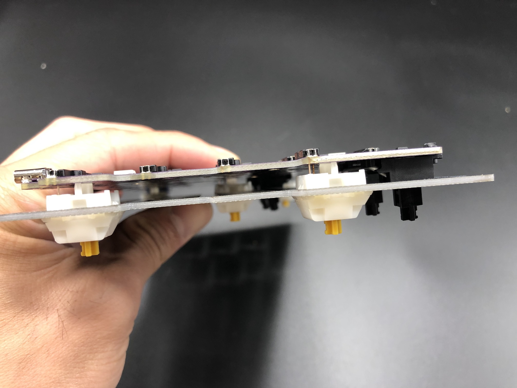 Side view of PCB and switch plate being aligned